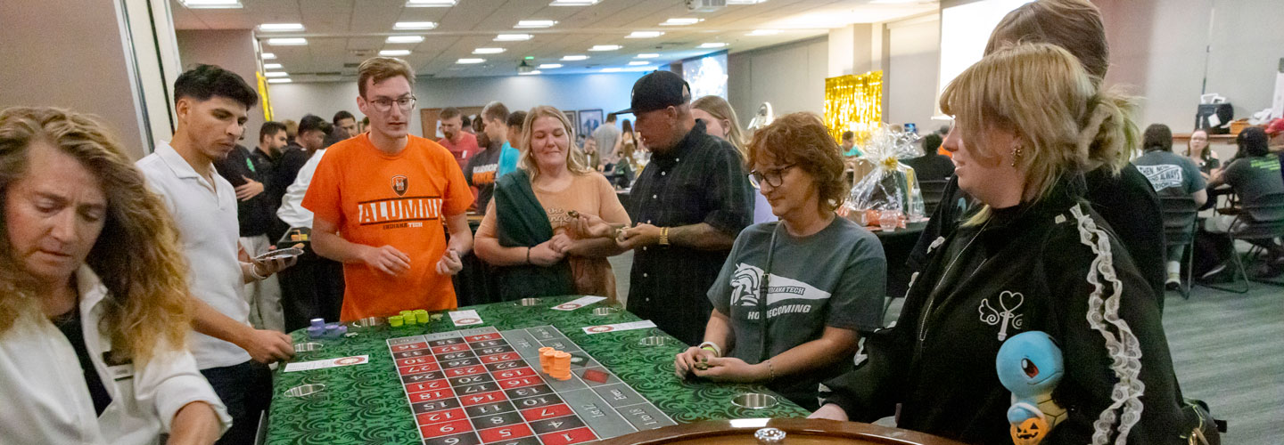 Alumni around a roulette table at Casino Night at Homecoming